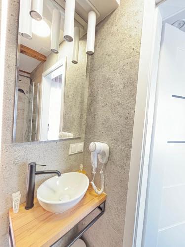 a bathroom with a sink and a mirror at ApartHotel Centrum - parking free in Białystok