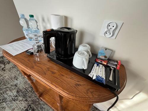 a wooden table with a coffee maker on it at ApartHotel Centrum - parking free in Białystok