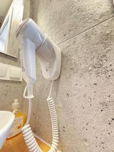 a hair dryer hanging on a wall next to a sink at ApartHotel Centrum - parking free in Białystok
