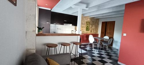 une cuisine avec un comptoir et des tabourets dans une pièce dans l'établissement la petite charentaise, à Beurlay