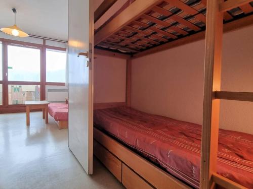 une chambre avec deux lits superposés et une table dans l'établissement Appartement cosy 6 pers, balcon exposé, proche pistes et commerces, parking, navette, Wifi gratuit - FR-1-525-218, à Saint-Étienne-en-Dévoluy