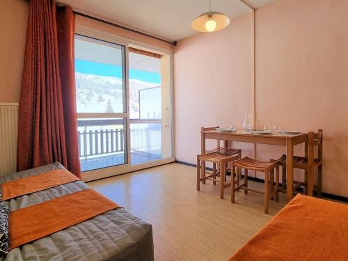 - une chambre avec une table et des chaises et un balcon dans l'établissement Studio cosy avec WIFI à 50m des pistes - 4 pers - FR-1-525-237, à Saint-Étienne-en-Dévoluy
