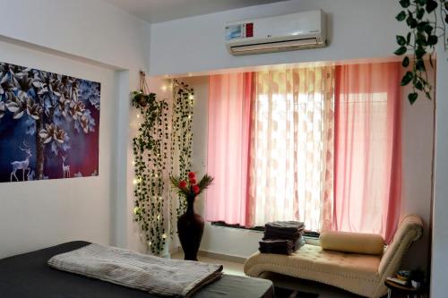 1 dormitorio con cama, ventana y sofá en Zoey's Hill View en Navi Mumbai