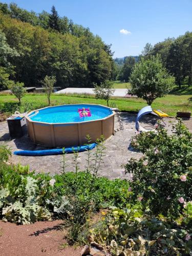 - une piscine dans une cour avec un jardin dans l'établissement Relais nature et randonnées, à Écromagny