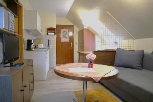 een kleine woonkamer met een tafel en een bank bij Birkenstübchen in Lautenthal