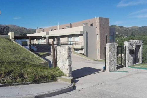 un edificio con cancello di fronte a un edificio di Departamento con vista al lago a Potrero de los Funes