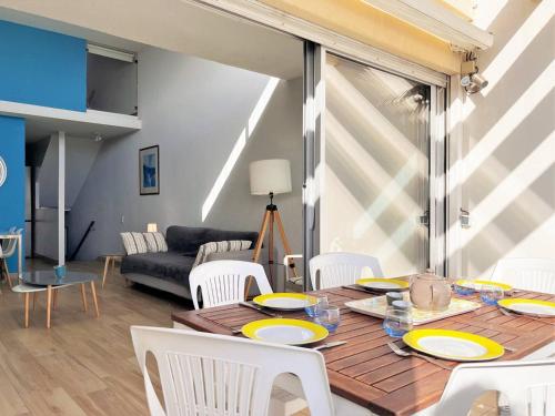 - une table à manger avec des assiettes jaunes dans le salon dans l'établissement Appartement climatisé 3 pièces, 6 couchages - Face à la plage - Le Lavandou - FR-1-251-510, au Lavandou