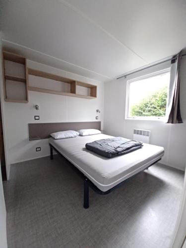 烏爾加特的住宿－Mobil home équipé camping 5*，一张位于带大窗户的房间内的床铺