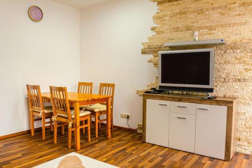 a dining room with a table and a television on a counter at Helle Wohnung nähe Highline 179 