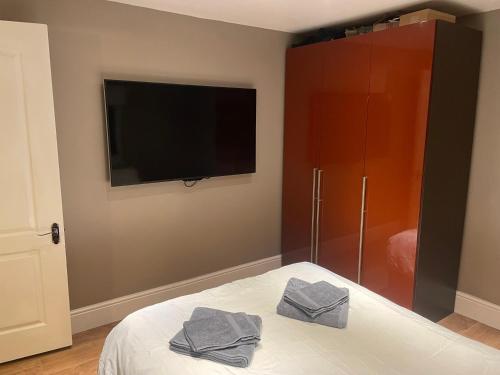 a bedroom with a tv and a bed with two towels at Bedroom 4 in Barton in the Clay