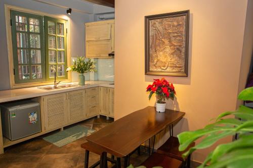 a kitchen with a wooden table with flowers on it at Chez Van in Hanoi