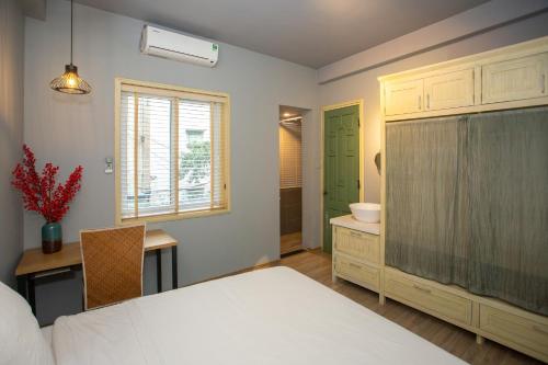a bedroom with a bed and a desk and a sink at Chez Van in Hanoi