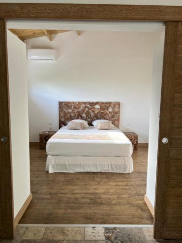 a bedroom with a bed with a stone headboard at La Villa Paille en Queue in Saint-Gilles les Bains