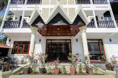 a building with potted plants in front of it at LuangPrabang Center Hotel in Luang Prabang