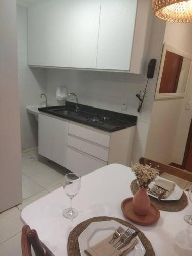 a kitchen with a white table with a white counter top at Apartamento Aconchegante in Brasília