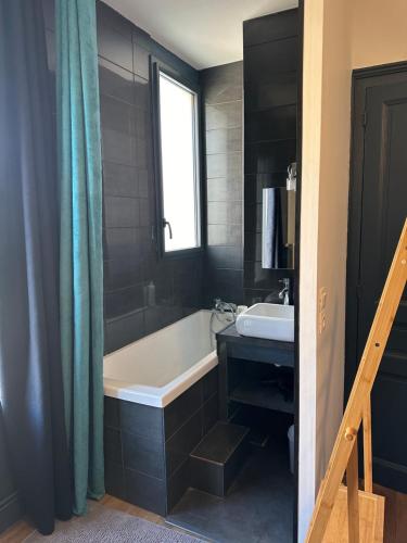 a bathroom with a bath tub and a sink at Maison de ville idéalement placée in Tours