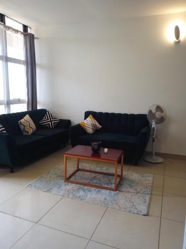 a living room with a couch and a coffee table at Eika Suites at Acacia in Kampala