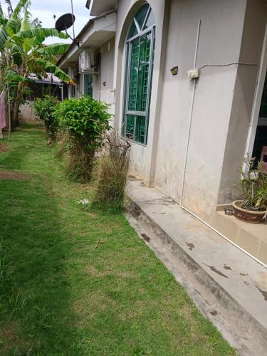 a house with a yard next to a building at Homestay Othman Perlis-14pax-AC-Wifi-Kangar-BBQ in Kangar