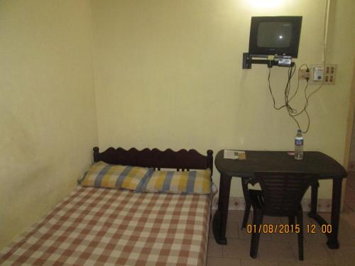 a small room with a bed and a small table at St. Antonys Lodge in Cochin