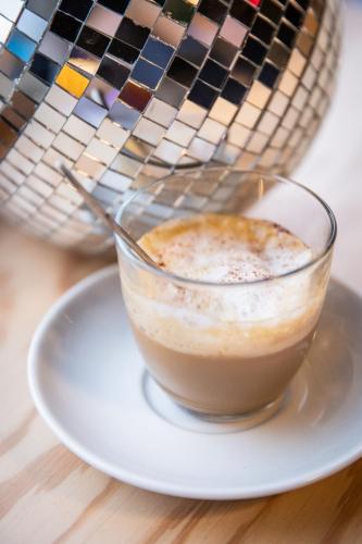 JOST Auberge de Jeunesse Le Havre Centre Gare في لو هافر: كوب من القهوة على طبق على طاولة