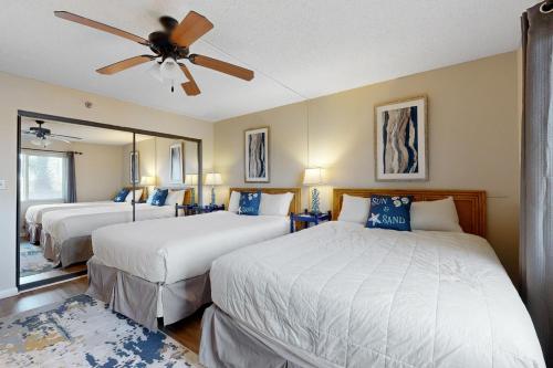 a bedroom with two beds and a ceiling fan at Surf Dweller 211 in Fort Walton Beach