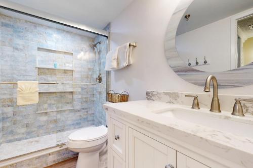 a bathroom with a sink and a toilet and a mirror at Surf Dweller 211 in Fort Walton Beach