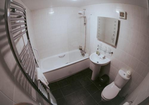 a bathroom with a tub and a sink and a toilet at The Heathfield Inn in Honiton