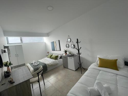 um quarto branco com uma cama e um sofá em AIOLOS Chania centre luxury apartment em Chania Town
