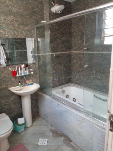 a bathroom with a shower and a toilet and a sink at Quarto Vila Mariana in São Paulo