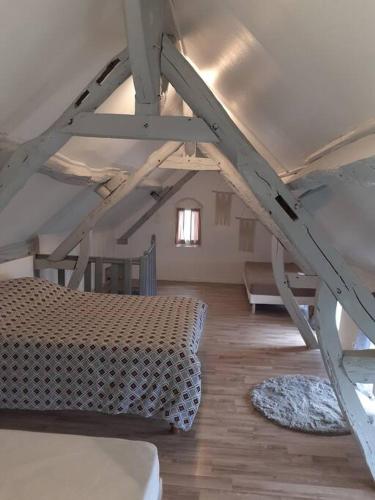 een zolderkamer met een bed en een ladder bij Maison Diana à 400 mètres à pieds de l'aéroport in Tillé
