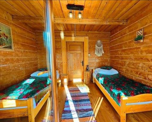Duas camas num camarote com paredes de madeira em STYLOWE APARTAMENTY W PORONINIE em Poronin