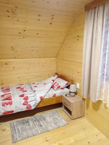 a bedroom with a bed in a wooden room at Dobar Pogled 2 in Kamenjača