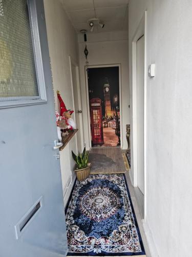 a hallway with a rug on the floor next to a door at Cheshunt House in London