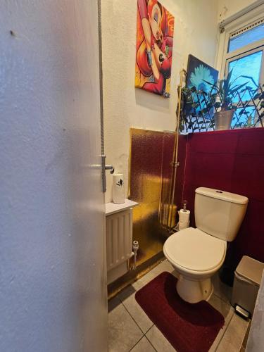 a bathroom with a toilet and a painting on the wall at Cheshunt House in London