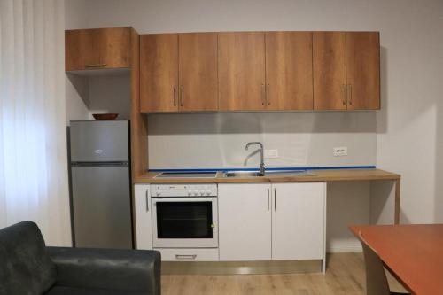a small kitchen with a sink and a refrigerator at Albora Guest House in Fier