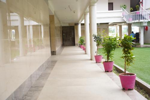 un pasillo vacío de un edificio con macetas en Hotel Millennium Plaza, en Jamnagar