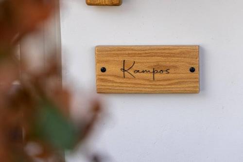 a wooden sign on a wall with the word karma at Raffar luxury houses in Tinos Town