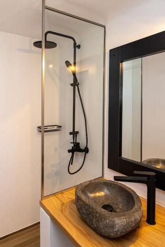 a bathroom with a rock sink on top of a counter at Raffar luxury houses in Tinos Town