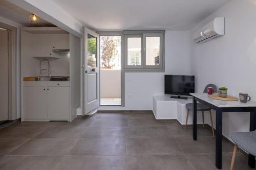 a kitchen and living room with a table and a television at Raffar luxury houses in Tinos Town