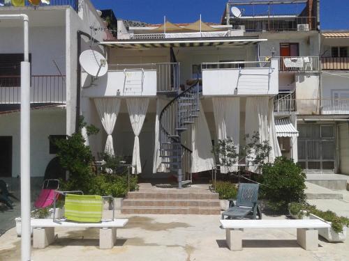 two benches sitting in front of a building at Apartments Toma Bajnice Directly in Krilo