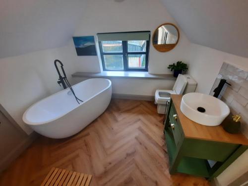 baño con bañera blanca grande y lavamanos en Corradiller Quay, Lisnaskea, Fermanagh en Lisnaskea