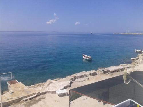 a small boat in the water near the shore at Apartments Toma Bajnice Directly in Krilo