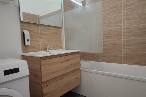 La salle de bains est pourvue d'un lavabo, d'une baignoire et de toilettes. dans l'établissement N°2 Seclin - Appartement plein cœur - 1 chambre, à Seclin