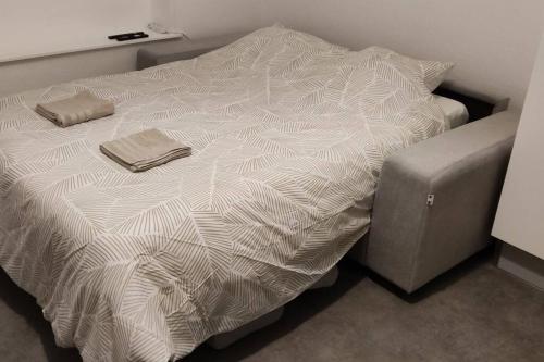 - un lit avec une couette blanche dans l'établissement N°2 Seclin - Appartement plein cœur - 1 chambre, à Seclin
