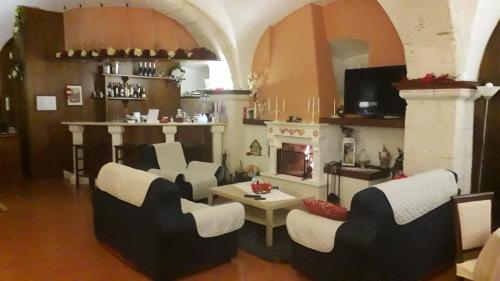 ein Wohnzimmer mit Stühlen und einem Kamin in der Unterkunft Hotel Natros in Rocca Pia