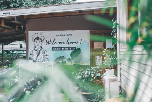 Un cartel en el lateral de un edificio con plantas. en Yor Song Hostel Pai, en Ban Huai Pu