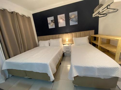 duas camas num pequeno quarto com duas camas sidx sidx em Suíte Studio 1 Enseada Tortuga Mobiliada no Guarujá