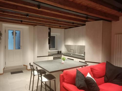 素蒂歐的住宿－Cjase Vecje，一间带红色沙发的客厅和一间厨房