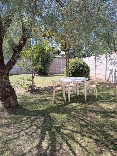 una mesa blanca y dos sillas bajo un árbol en Elena en Carhué