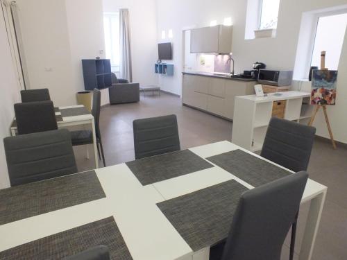 Una habitación con una mesa y sillas y una cocina. en Re Federico Apartment, en Palermo